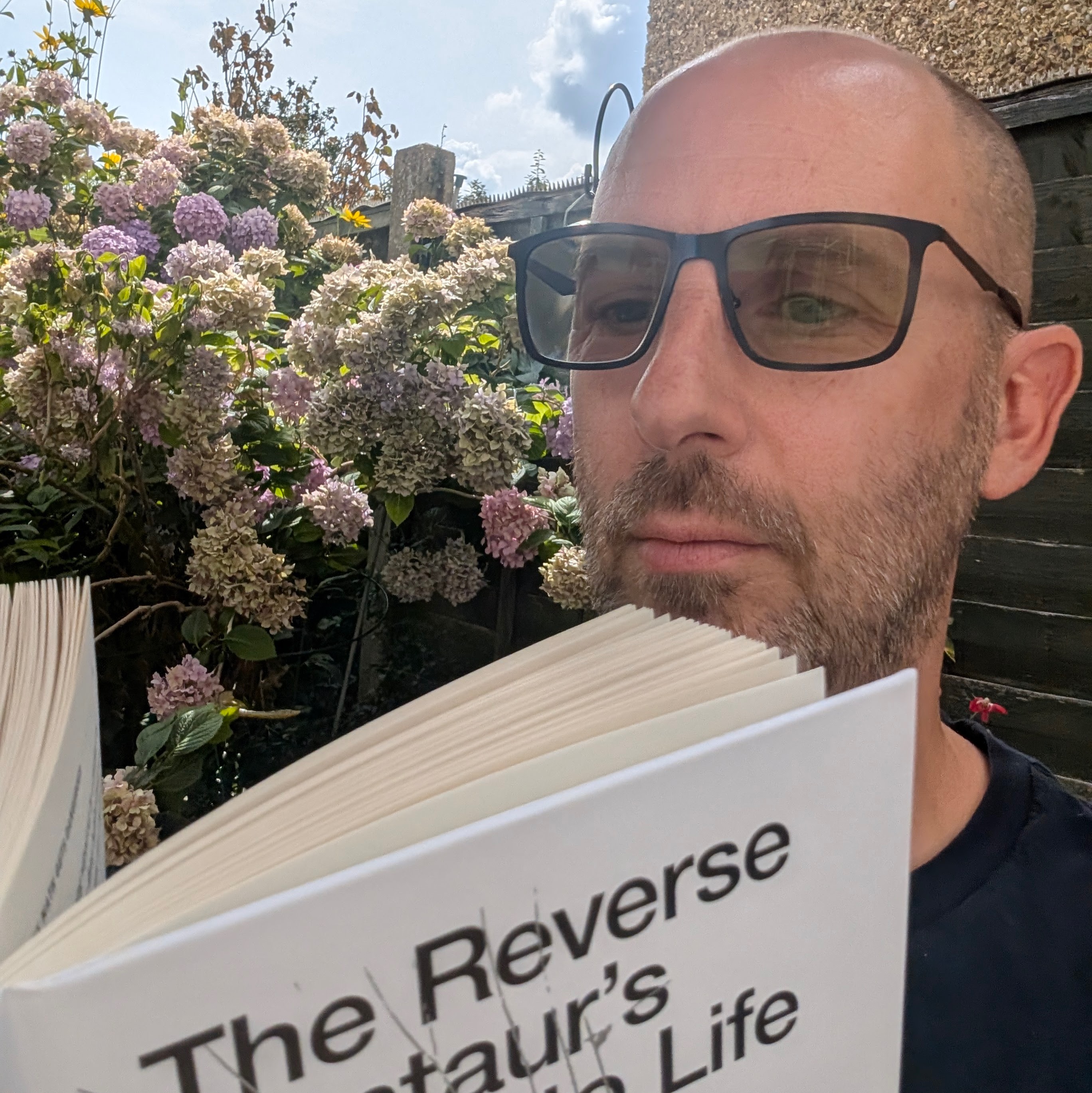 Garden selfie while reading The Reverse Centaur&rsquo;s Guide to Life After AI
